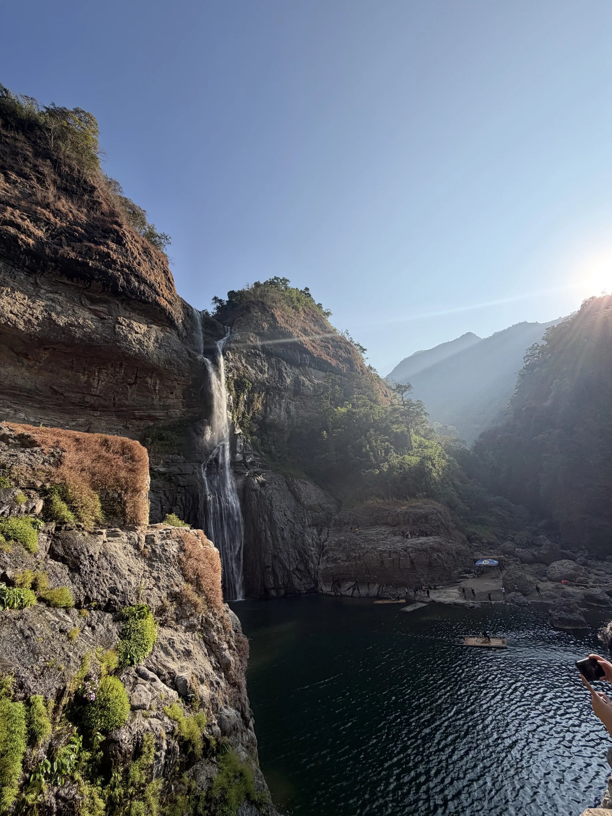 A waterfall flowing between rocky cliffs into a natural pool